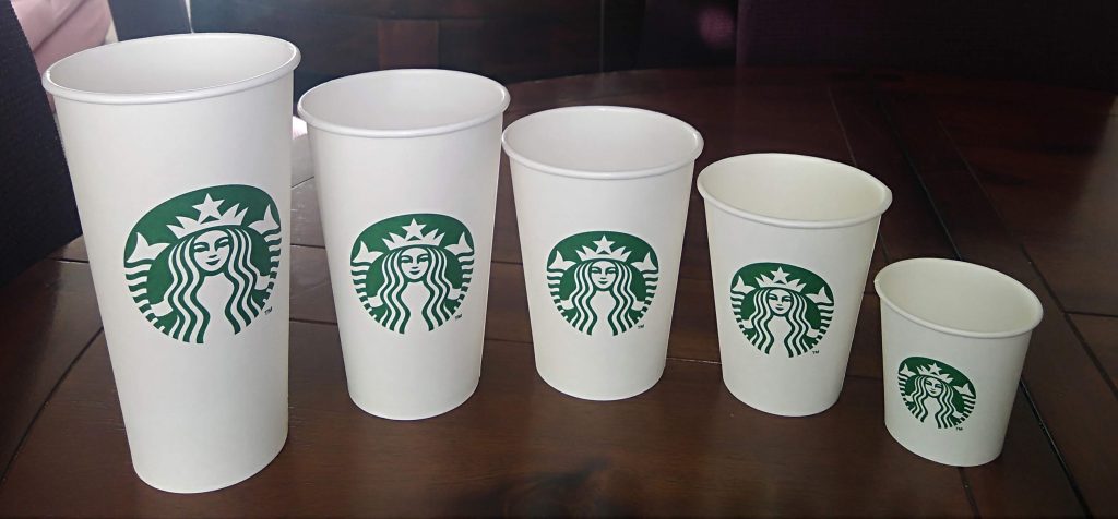 Bicchiere da caffè in cartone Starbucks su scrivania da ufficio